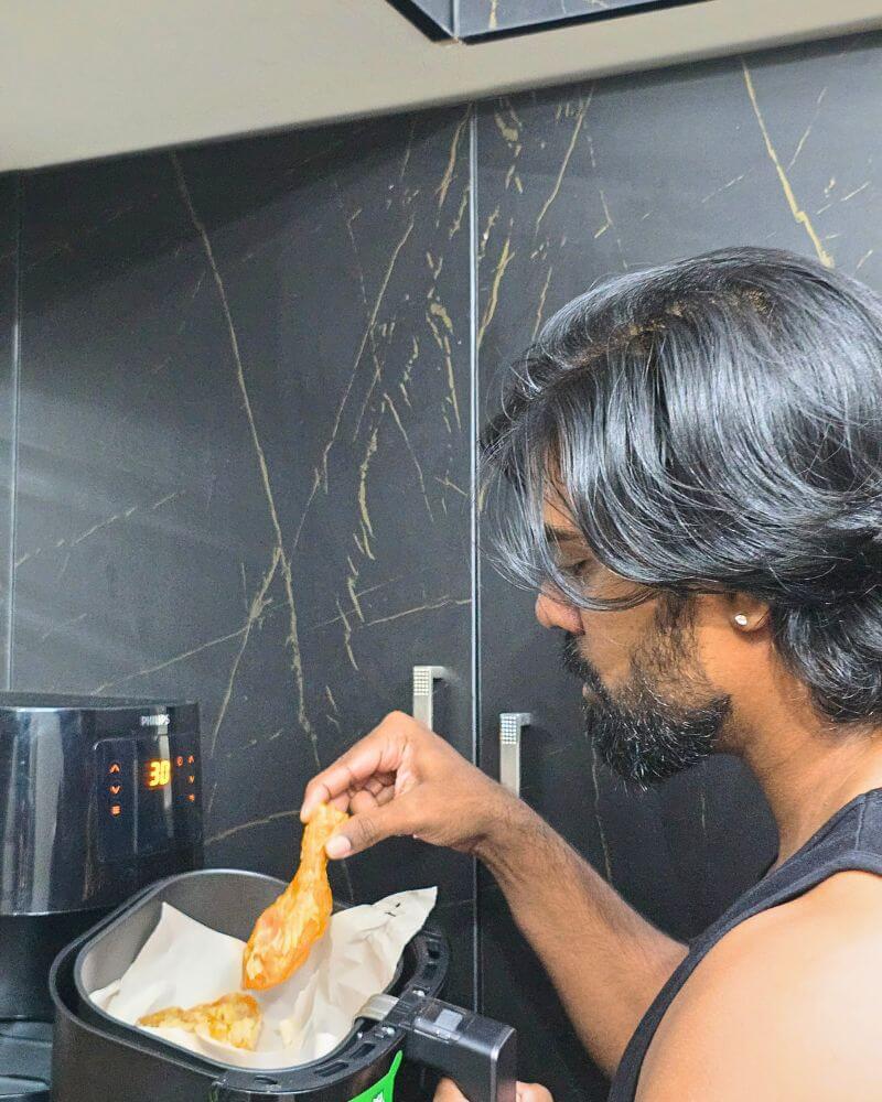 Man preparing gym-friendly fried rice using air fryer