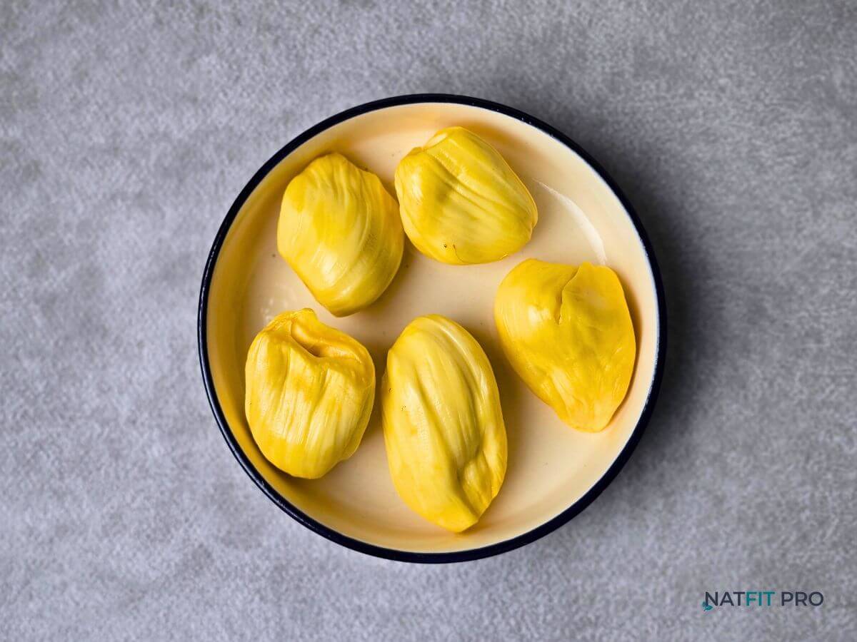 Ripe jackfruit pods in a bowl, a calorie-dense and carb-rich fruit for fueling a calorie surplus.