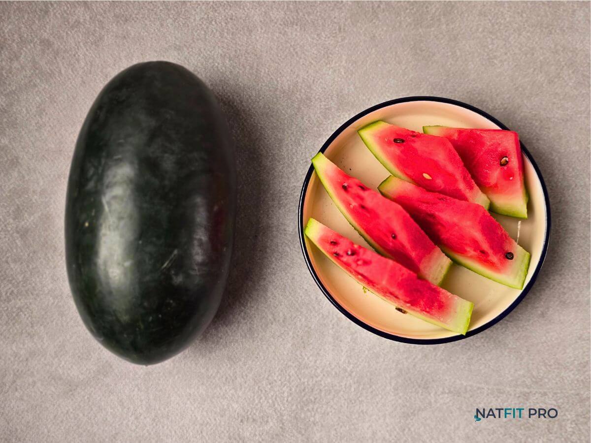 A whole watermelon next to a plate of fresh, juicy slices, a perfect fruit for natural hydration.