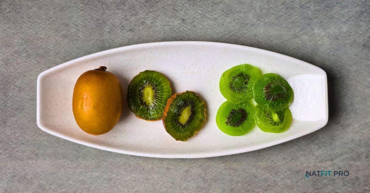 A comparison of a whole and sliced fresh kiwi versus sweet, chewy dried kiwi slices on a white platter.