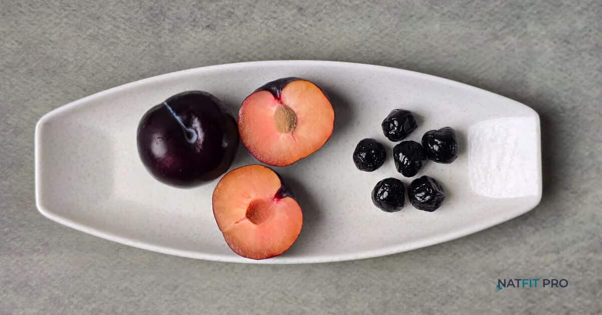 A direct comparison of juicy, sliced fresh plums versus their dried counterparts, prunes, on a white platter.