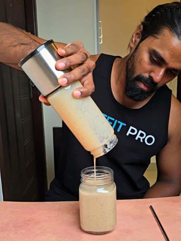 Tamil Arasan of Natfit Pro pouring his homemade Dried Fruit Power Shake in a mason jar.