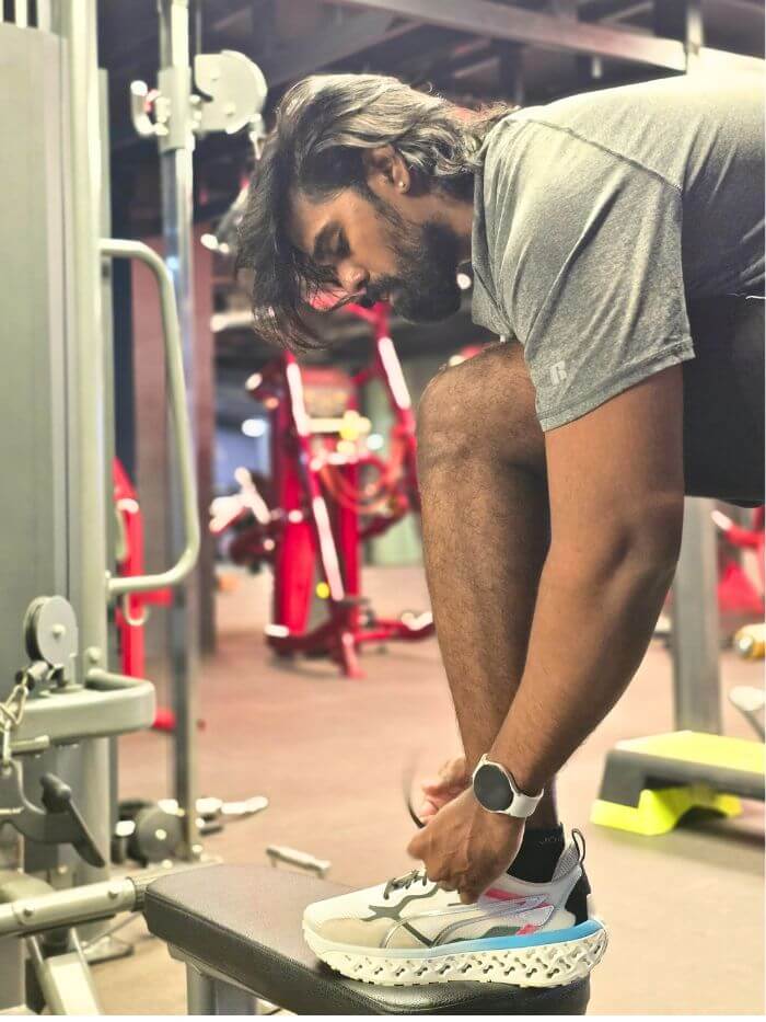 training-shoes-closeup-gym-natfitpro Tamil tying his training shoes before a workout at the gym.