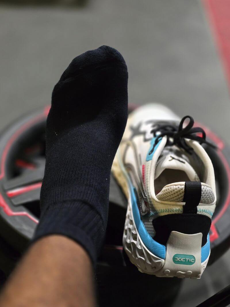 Tamil wearing black training socks with shoes on weight plate