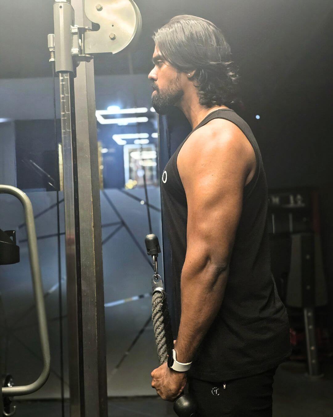 triceps-pushdown-rope-natfitpro Man executing triceps rope pushdown exercise on cable machine at Natfit Pro gym